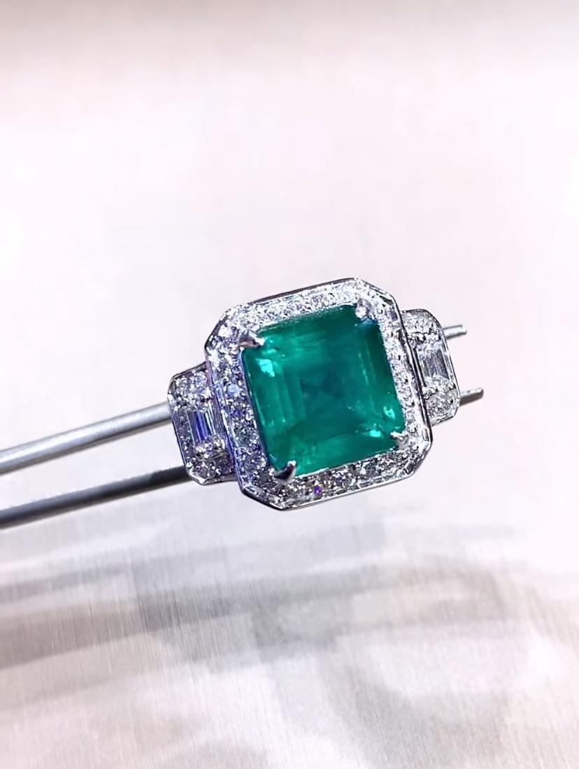 ¡Recién hecho! Un anillo exclusivo con diseño Art Déco que destila elegancia atemporal.
Las esmeraldas, con su tono verde verdoso, cautivan la mirada con su vibrante brillo. Entre las esmeraldas hay brillantes diamantes, que añaden un toque de