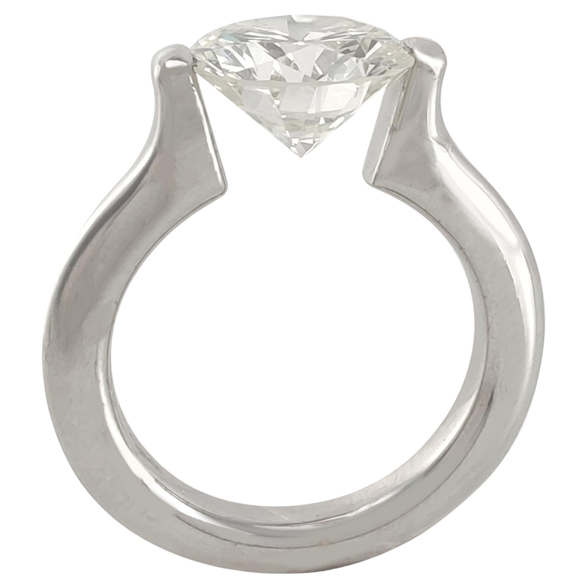 Cette bague, fabriquée à la main en or blanc 18 carats, est une véritable œuvre d'art. Avec un spectaculaire diamant de 4 carats monté en l'air, elle permet à la lumière de passer à travers le diamant et d'en souligner l'éclat et la beauté. Cette