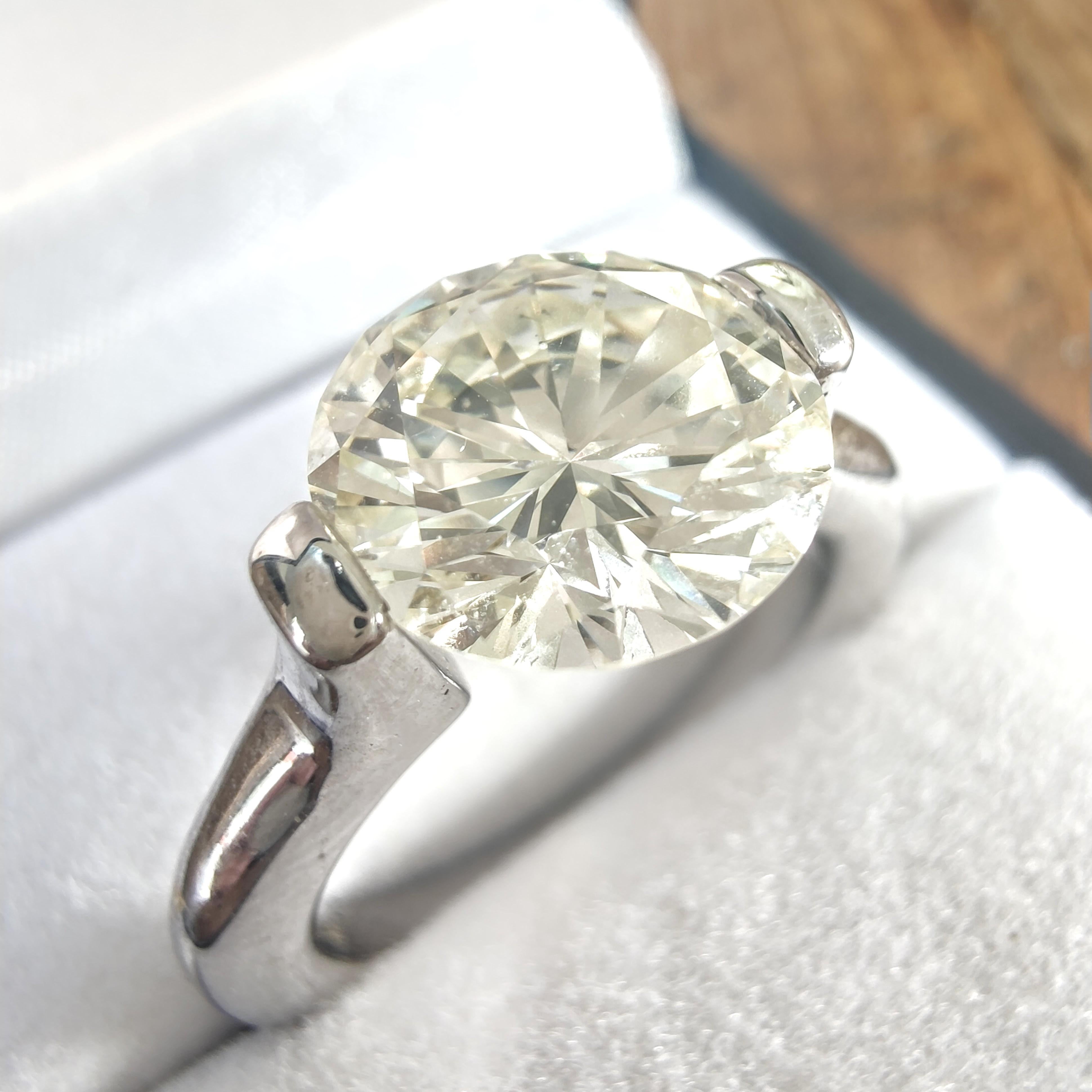 Questo anello è realizzato a mano in oro bianco da 18 carati ed è una vera e propria opera d'arte. Con uno spettacolare diamante da 4 carati montato in aria, permette alla luce di passare attraverso il diamante e di evidenziarne la brillantezza e la