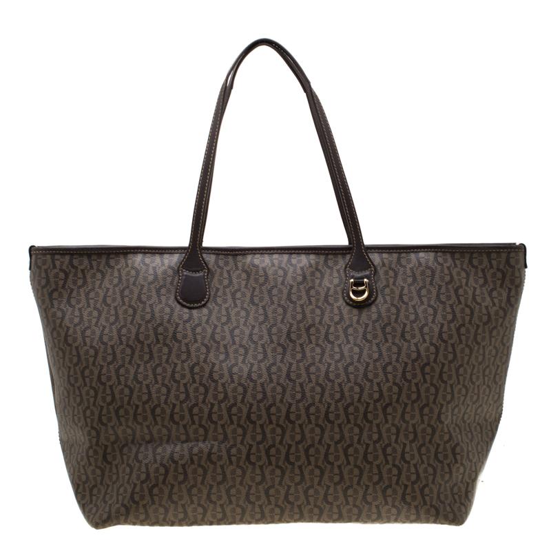 A lovely mix of style and durability, this Aigner tote will live up to your expectations. Crafted from signature coated canvas the bag can be held using the dual handles. The nylon lined spacious interior is secured by a zip top closure.

Includes: