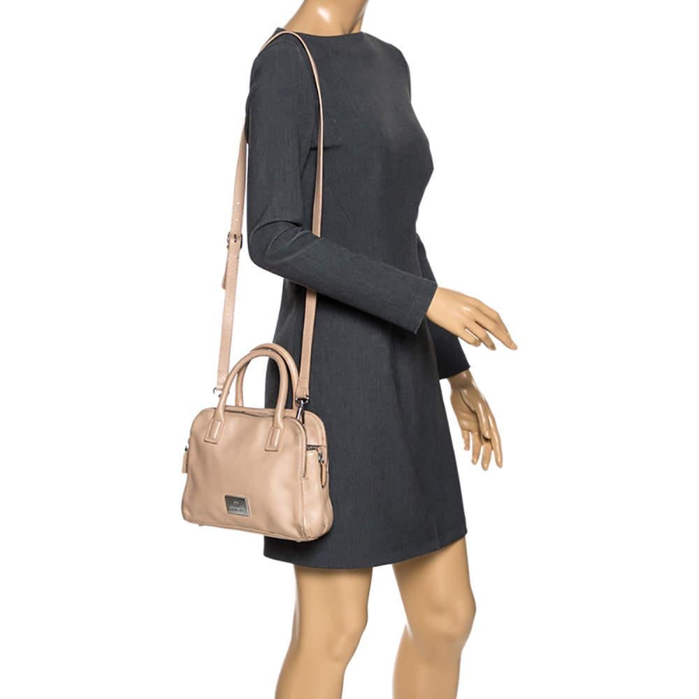 Lift your spirit a notch higher with this bag from Aigner. This beige creation is crafted from leather and features top handles and a shoulder strap. The buttoned closure opens to a fabric-lined interior that will store all your necessities. 