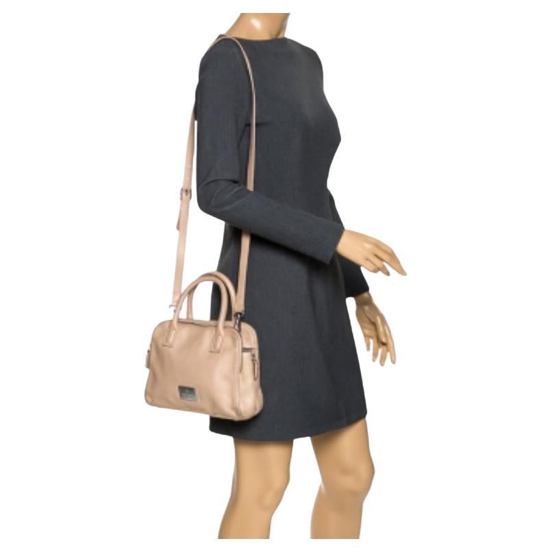 Solleva il tuo spirito con questa borsa di Aigner. Questa creazione beige è realizzata in pelle e presenta manici e tracolla. La chiusura con bottoni si apre su un interno foderato in Fabrice che ti permetterà di riporre tutte le tue necessità.