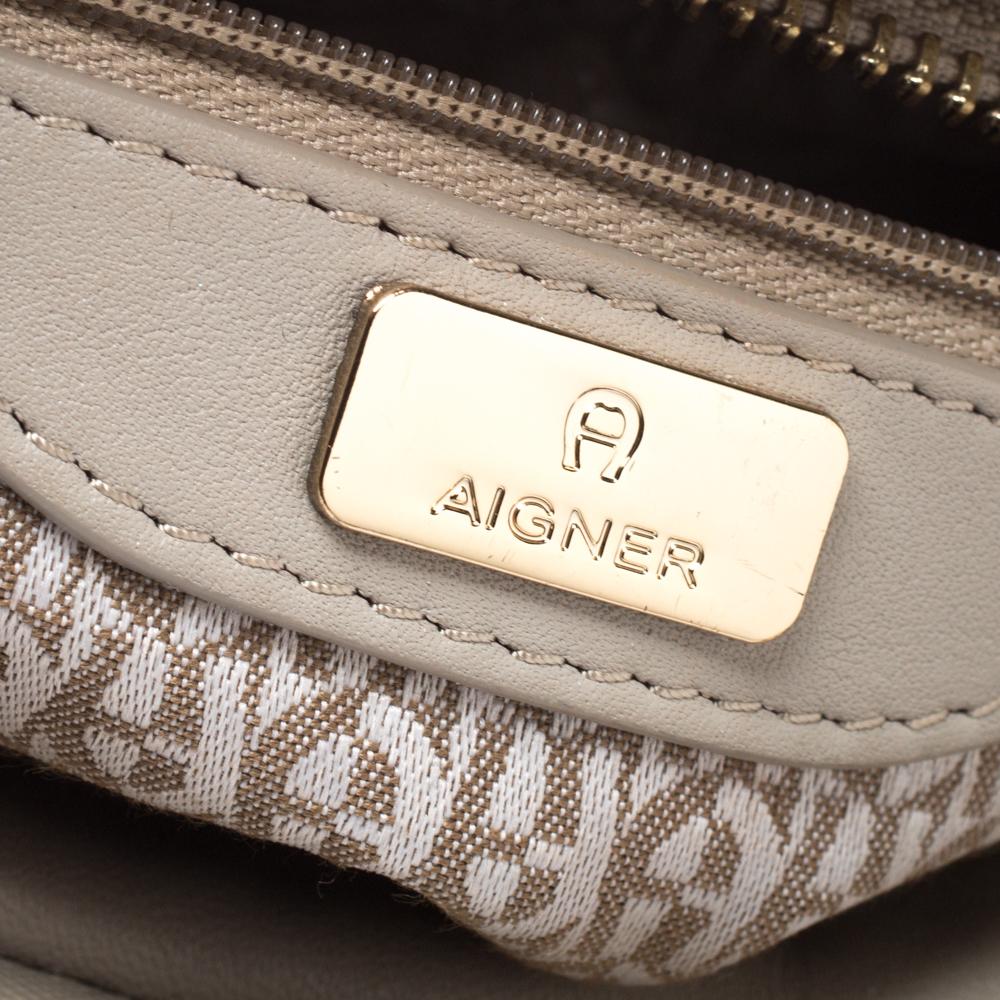 This beige satchel from Aigner will give you days of style and ease. It is crafted from leather and features a dangling gold-tone logo charm. It is equipped with a spacious fabric interior, two handles and metal feet.

Includes: The Luxury Closet
