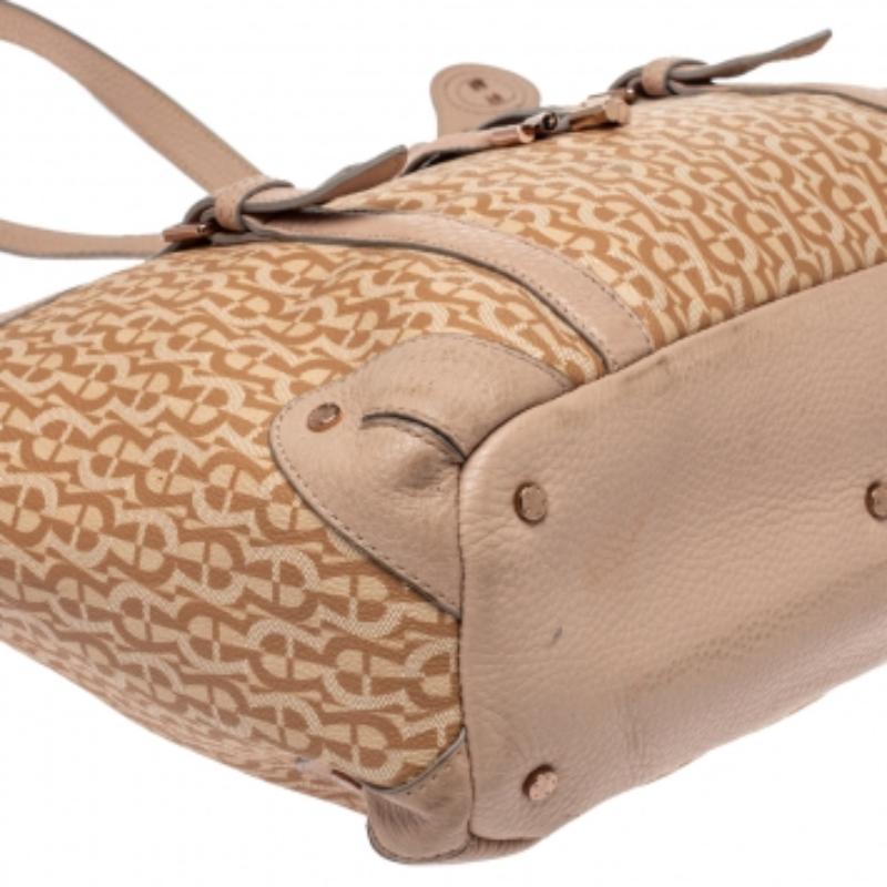 Made from signature coated canvas & leather, this beige & pink Aigner tote demands attention. Carry this trendy creation as it has a spacious fabric interior, two handles, and a front bow detail with rose gold-tone hardware. Represent the
