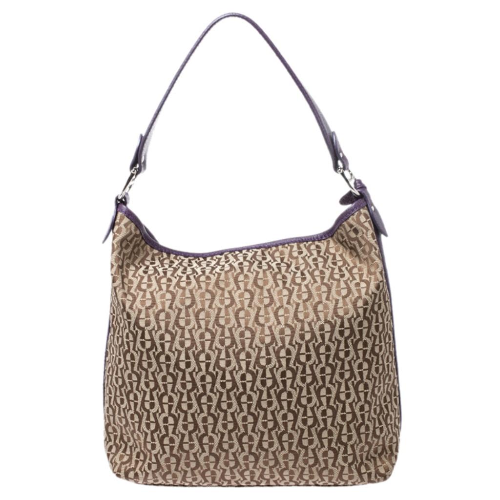 Flaunt your fashion quotient by adorning this hobo from Aigner. Crafted from signature canvas and leather, the bag can be held using the dual handles. The fabric-lined spacious interior is secured by a snap button closure.

Includes: The Luxury