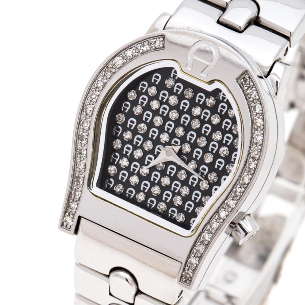 Flaunt your elegant style by owning this luxe wristwatch from Aigner. Swiss made and created from stainless steel, this watch follows a Quartz movement and has a beautiful dial covered in the brand logo and diamonds. The bezel is also shaped as the