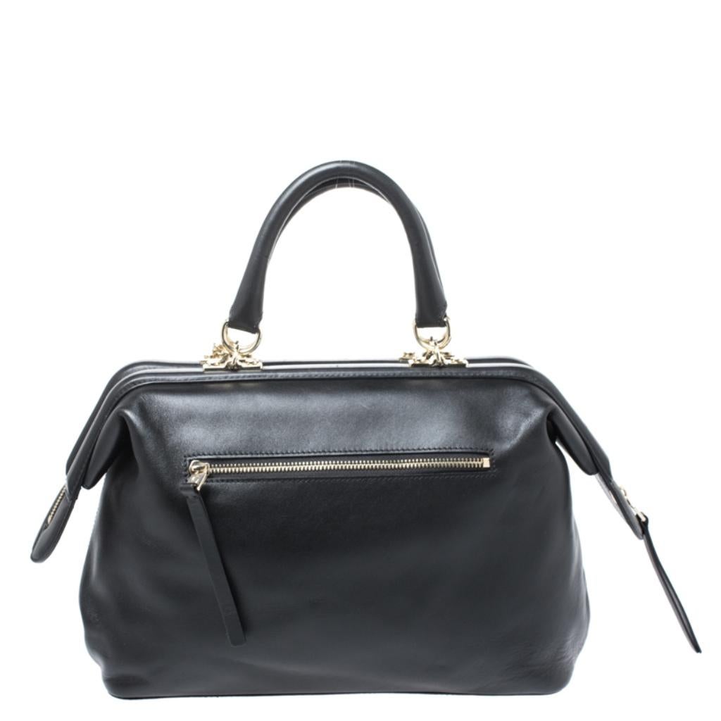 This Boston bag by Aigner is stylish and functional. Crafted from quality leather, it comes in a lovely shade of black. It is held by dual handles and a single shoulder strap. It is styled with a top-zip closure that opens to reveal a fabric