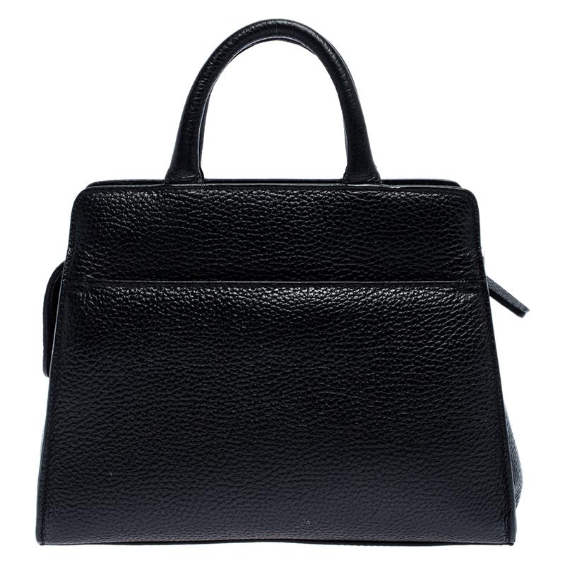 Characterised by its structured, trapezoidal shape, this Cybill tote by Aigner personifies elegance, charm and sophistication. It is made from textured leather flaunting a timeless black shade and is designed minimally with a petite logo at the
