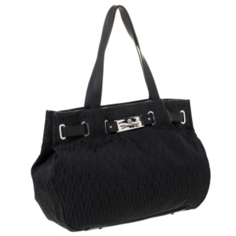 This stylish tote bag by Aigner has been crafted to assist you with ease and style on all days. It is crafted from signature canvas and leather. The black tote features a belt-like detail, two handles and a spacious nylon interior.