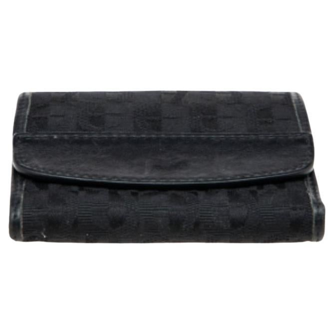 Issu de la maison Aigner, ce portefeuille est un accessoire qu'il vous faut posséder dès aujourd'hui ! Il est fabriqué en toile Signature noire et en cuir à l'extérieur. Il est doté d'un intérieur en cuir et d'accessoires de couleur argentée.