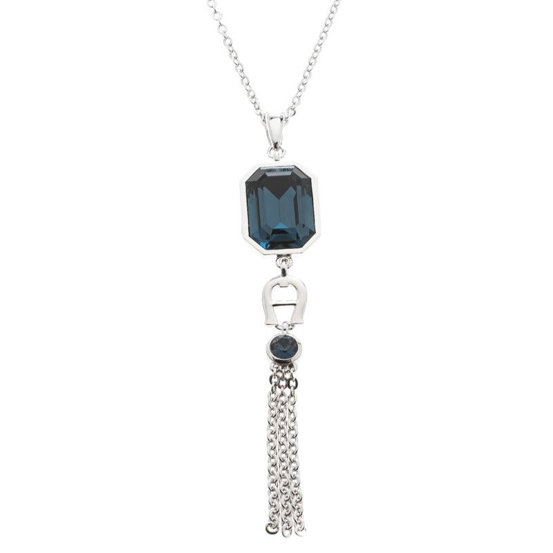 It is definitely Love At First Sight with this pendant and earrings set from Aigner. Beautifully crafted from silver-tone metal, the set has a pendant necklace and matching earrings. An octagon-cut crystal in blue, the brand logo and a chain tassel