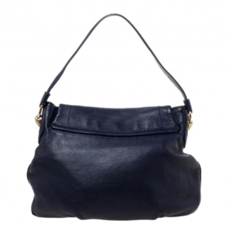 This Aigner handbag exhibits outstanding workmanship and is made from premium leather. The blue shade makes the bag versatile and the brand logo is displayed on the front for a signature touch. It has gold-tone hardware and flap closure. This hobo
