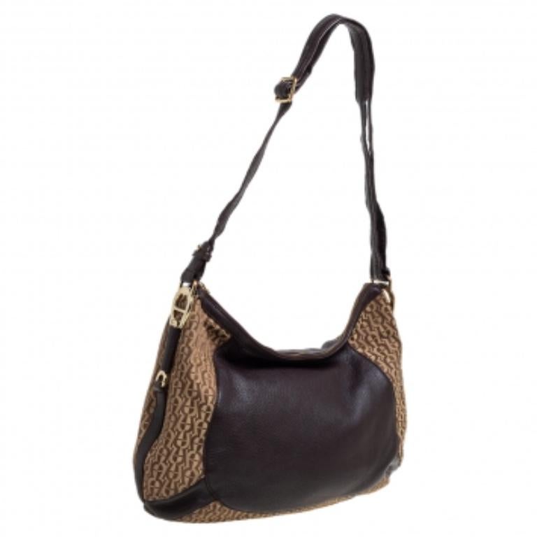 This bag is lined with fabric that allows you to keep your essentials safe. Make a style statement with this stylish signature canvas and leather hobo. Designed by Aigner, the bag has a single handle and a convenient size.