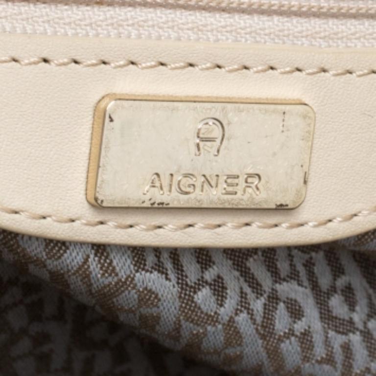 Designed to look nothing but flawless, this Cavallina bag from Aigner is a dream you can add to your collection! Fabulous in cream, it comes crafted from leather and features dual top handles, a strap looped around like a drawstring at the front,