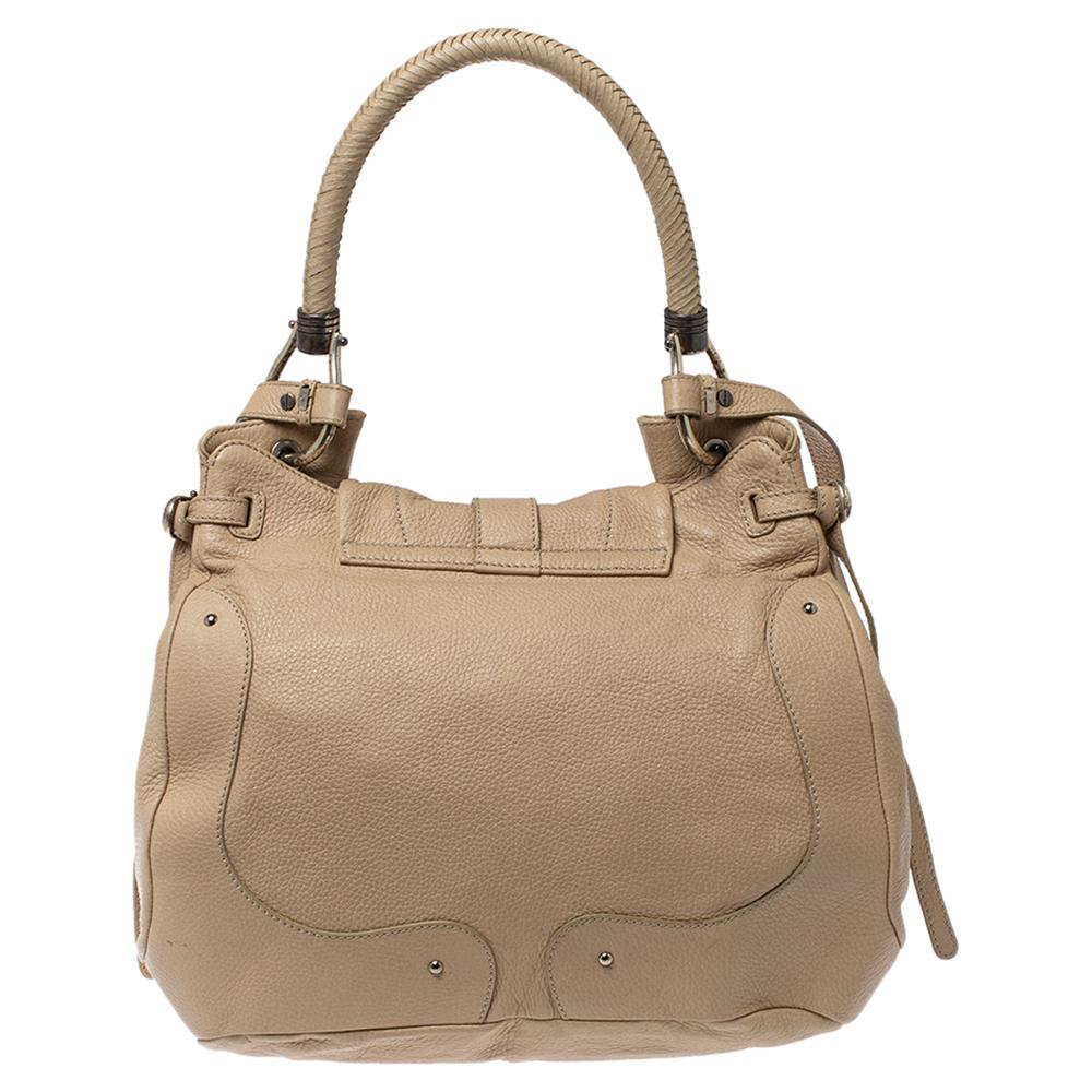 Artistically designed to help express your fashion-forward style, this Aigner bag is chic and practical at once. Made from leather in a cream hue, it features a flap that opens to a spacious interior for everyday essentials. Hold it by the top