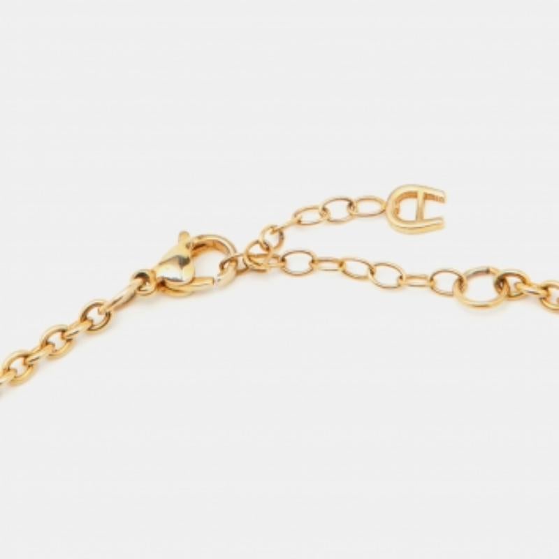 Diese Halskette von Aigner ist ein Beispiel für minimalen Stil mit einer Kette, die zwei Logos als Anhänger trägt. Die Halskette ist aus goldfarbenem Metall gefertigt und wird mit einem Karabinerverschluss geschlossen. Wir sind sicher, dass diese