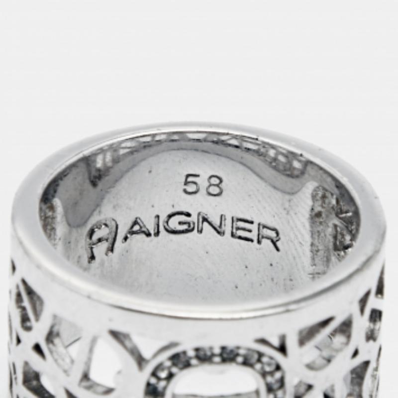 Aggiungi un tocco di classe al tuo look del giorno con questo anello di Aigner. Caratterizzato da una fascia in tonalità argento, questo anello è disegnato con un logo incastonato di cristalli. Indossalo impilato con altri anelli o come pezzo a sé