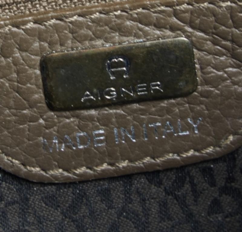 Characterized by its structured, trapezoidal shape, this Cybill tote by Aigner personifies elegance, charm and sophistication. It is made from grained eather flaunting a timeless dark beige shade and is designed minimally with a petite logo at the