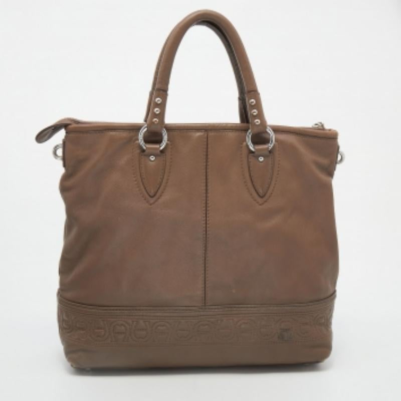 Diese Aigner-Tasche ist an den Markendetails am Boden leicht zu erkennen. Sie ist aus Leder gefertigt und verfügt über zwei Griffe, goldfarbene Beschläge und ein geräumiges, mit Stoff gefüttertes Innenleben.