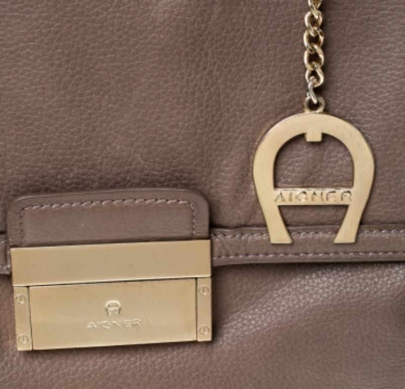 Diese Handtasche von Aigner hat Stil, ohne Kompromisse einzugehen. Diese verführerische Ledertasche hat ein elegantes Design mit einem Überschlag auf der Vorderseite, einem Griff an der Oberseite und einer Reißverschlusstasche auf der Rückseite.