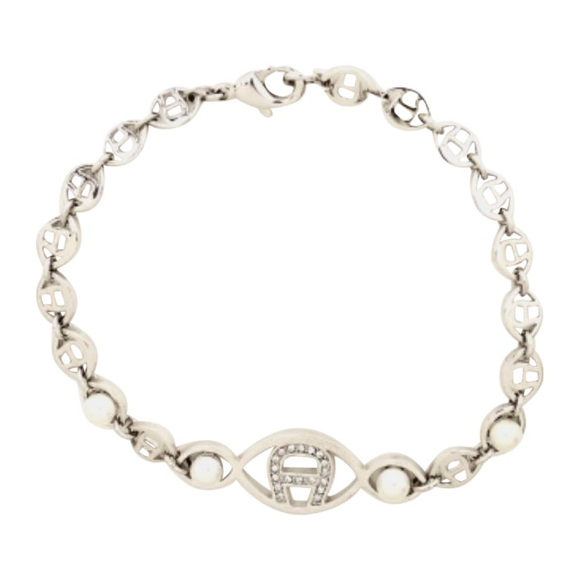 Bracciale Aigner Logo con cristalli e finte perle in tonalità argento