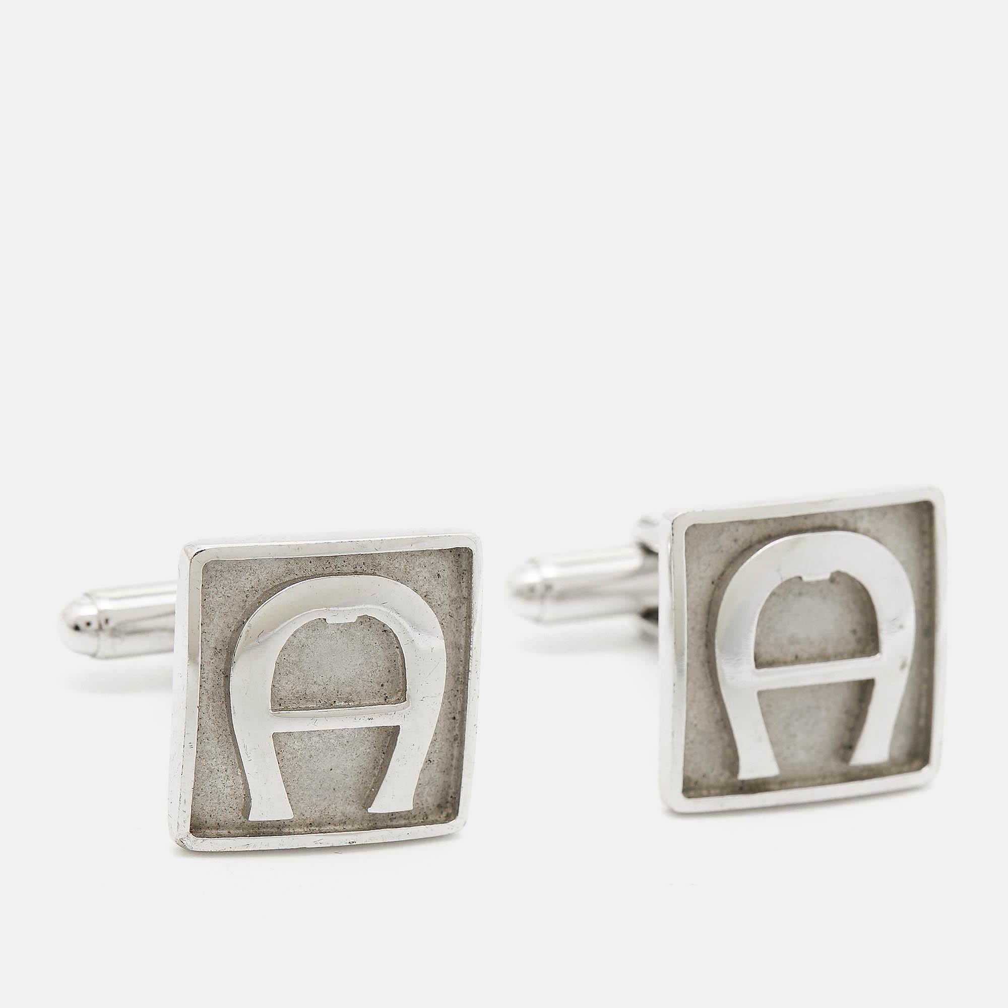 Diese Manschettenknöpfe zeugen von tadelloser Handwerkskunst und der luxuriösen Ästhetik von Aigner. Das silberfarbene Metalldesign mit Logo-Akzenten wird Ihre formellen Hemden wunderbar ergänzen.