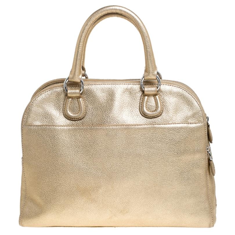 Be the talk of the town when you carry this Aigner handbag. Crafted with leather, this bag is styled with metallic gold hue all over, a top-zip closure and twin top handles. This chic satchel has an equally divine interior lined with fabric. This