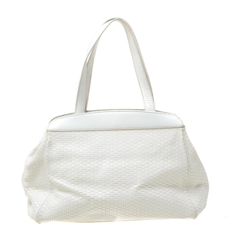 This stunning satchel is by Aigner. Crafted from off-white leather, the bag features weave patterns, two handles, and a spacious fabric interior. Place it in your arms to lend your outfit the appropriate measure of class and style.

Includes: The
