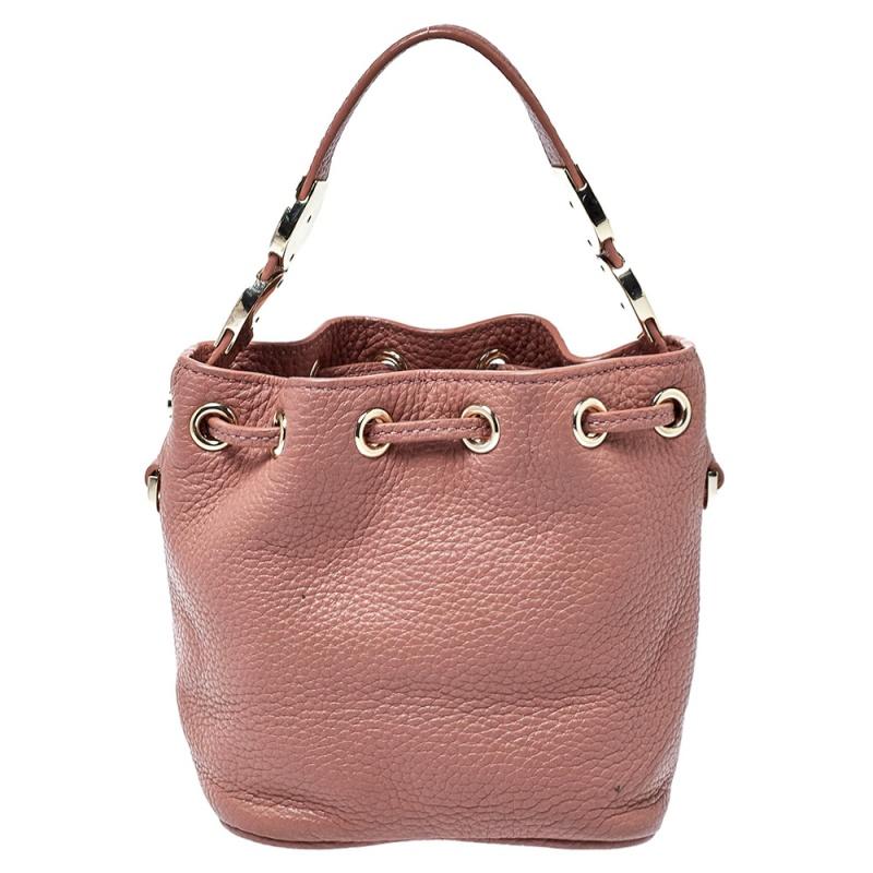A much-loved bag style, the bucket bag is a closet staple. The Aigner design exhibits a display of minimal details. This bag is crafted from grained leather and it has a top handle with logo detailing, a shoulder strap, and a fabric