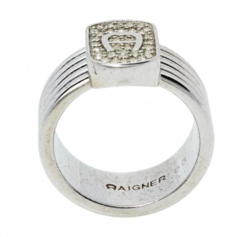 Add a statement finish to your look of the day with this Aigner ring. Featuring a silver-tone band, this ring is topped with a crystal embedded logo top. Wear it stacked with other rings or as a stand-alone piece.
