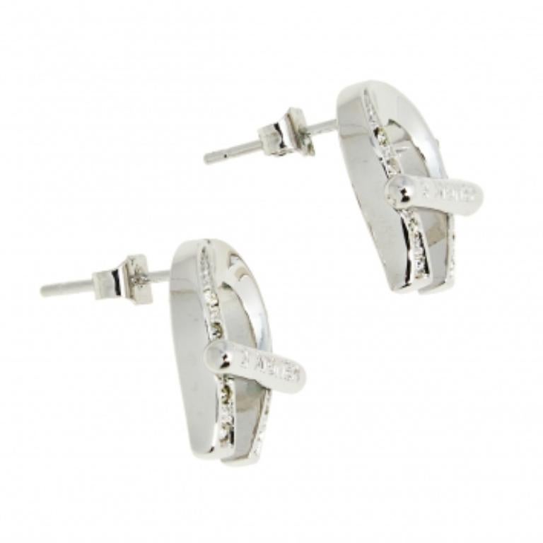 Que ce soit le jour ou la nuit, ces boucles d'oreilles étonnantes vous feront briller quelle que soit l'occasion. Signée Aigner, cette paire est dotée d'un clou et d'un corps en métal argenté, avec les motifs en forme de A décorés de cristaux. A