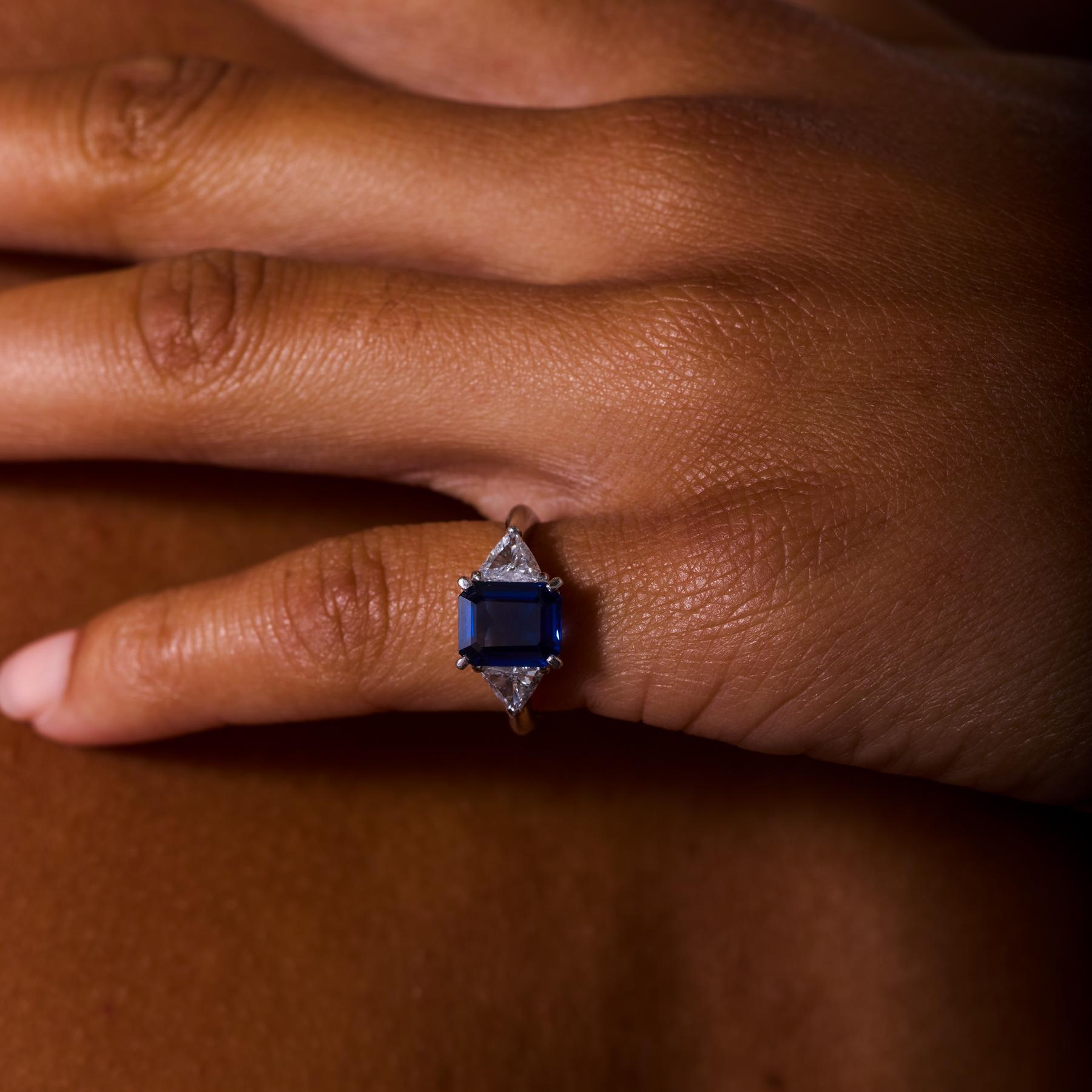 Élégante et intemporelle, cette bague de fiançailles vintage en platine met en valeur un saphir de 2,27 carats, certifié AIGS, d'un bleu éclatant, provenant de Madagascar. Les lignes nettes et l'éclat profond du saphir de taille émeraude sont