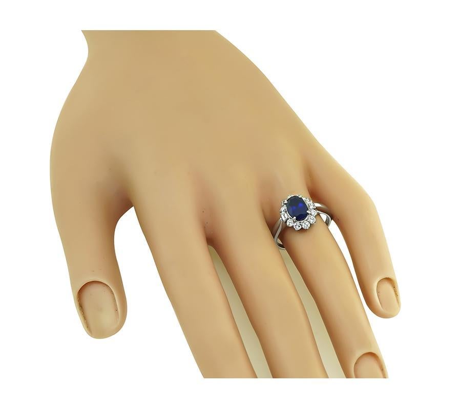 This is a charming platinum engagement ring. The ring is centered with a lovely AIGS certified oval cut sapphire that weighs approximately 1.74ct. The center stone is accentuated by sparkling round and emerald cut diamonds that weigh approximately