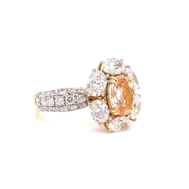 A scintillating Oval Padparadscha Sapphire weighing 1.34 Carats with a halo of Oval Brilliant Diamonds accented with Round Brilliant Cut Diamonds on the shank weighing a total of 2.72 cttw. Set in 18KT Yellow Gold.  Ring Size 7.

The unique design
