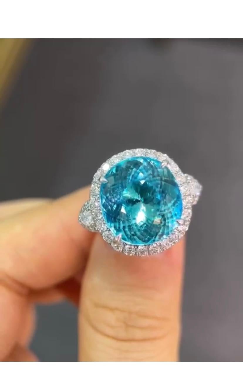 Un altro capolavoro è pronto!
Questo eccezionale  L'anello Paraiba e Diamanti è caratterizzato da una gemma Paraiba mozzafiato da 15,70 carati, che è la vera protagonista dell'anello. La vibrante tonalità di blu neon del Paraiba è completata da 