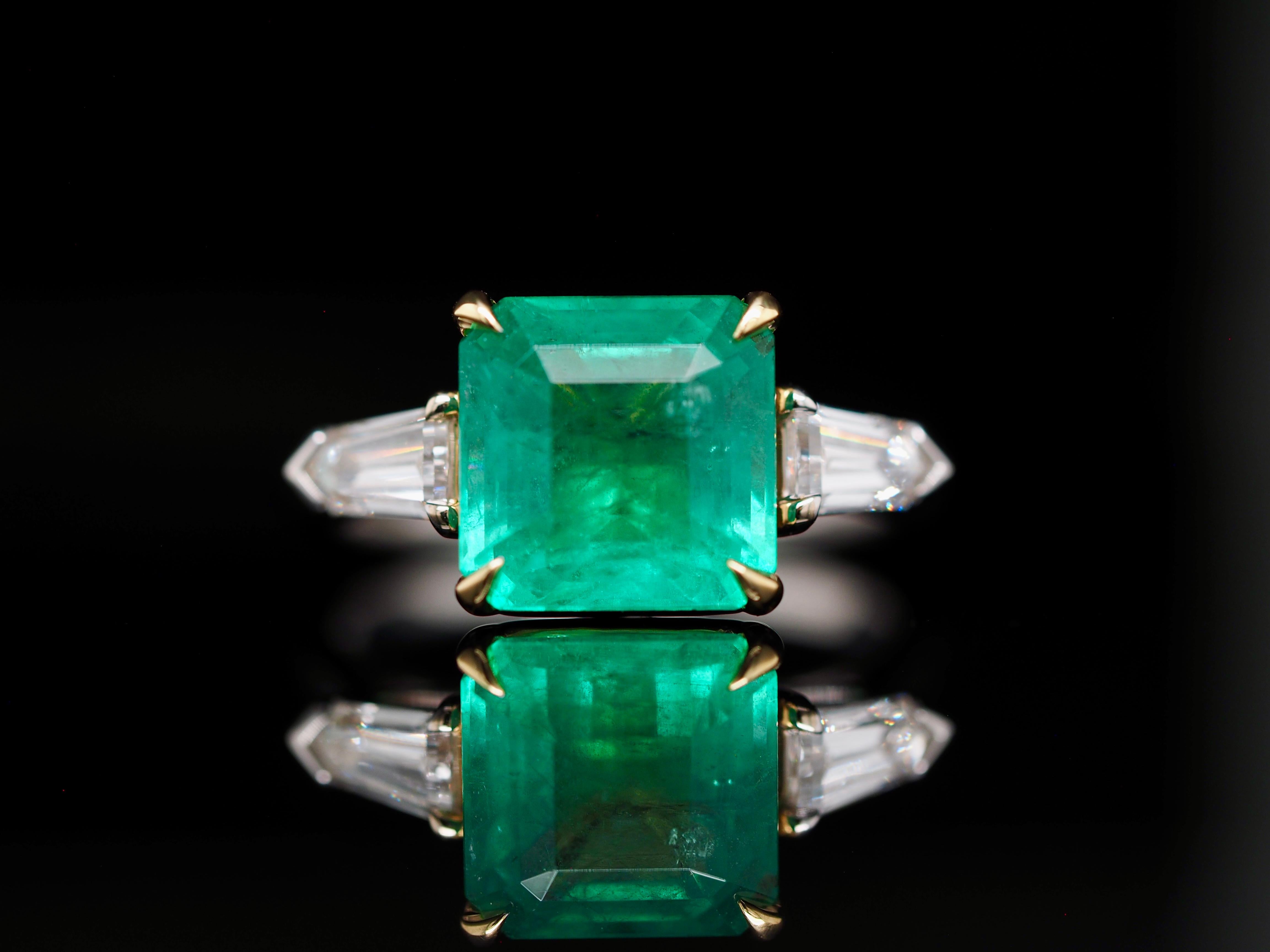 This mythical ring is straight out of a fantasy book. It has incredible natural deep green Zambia emerald. It's set in 18 karat white gold, with a gold detailed prong holding the emerald. Includes amazing bullet, cut diamond's on both sides of the