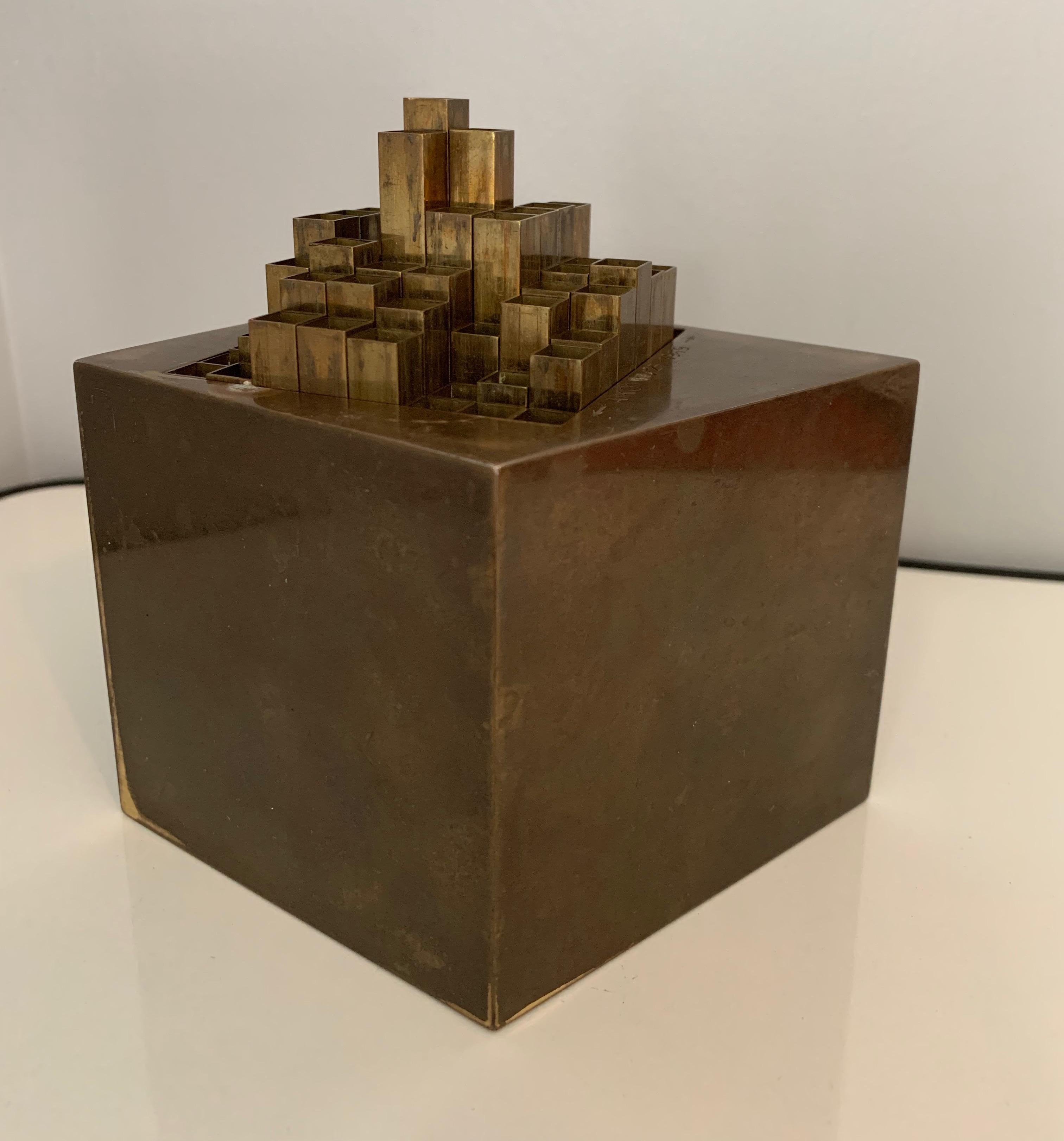 Sculptural and clever architectural desk top accessory with 64 square brass tubes that can be raised in any number of combinations. This piece has a wonderful mellow patina that shows years of wonderment. The piece is marked 