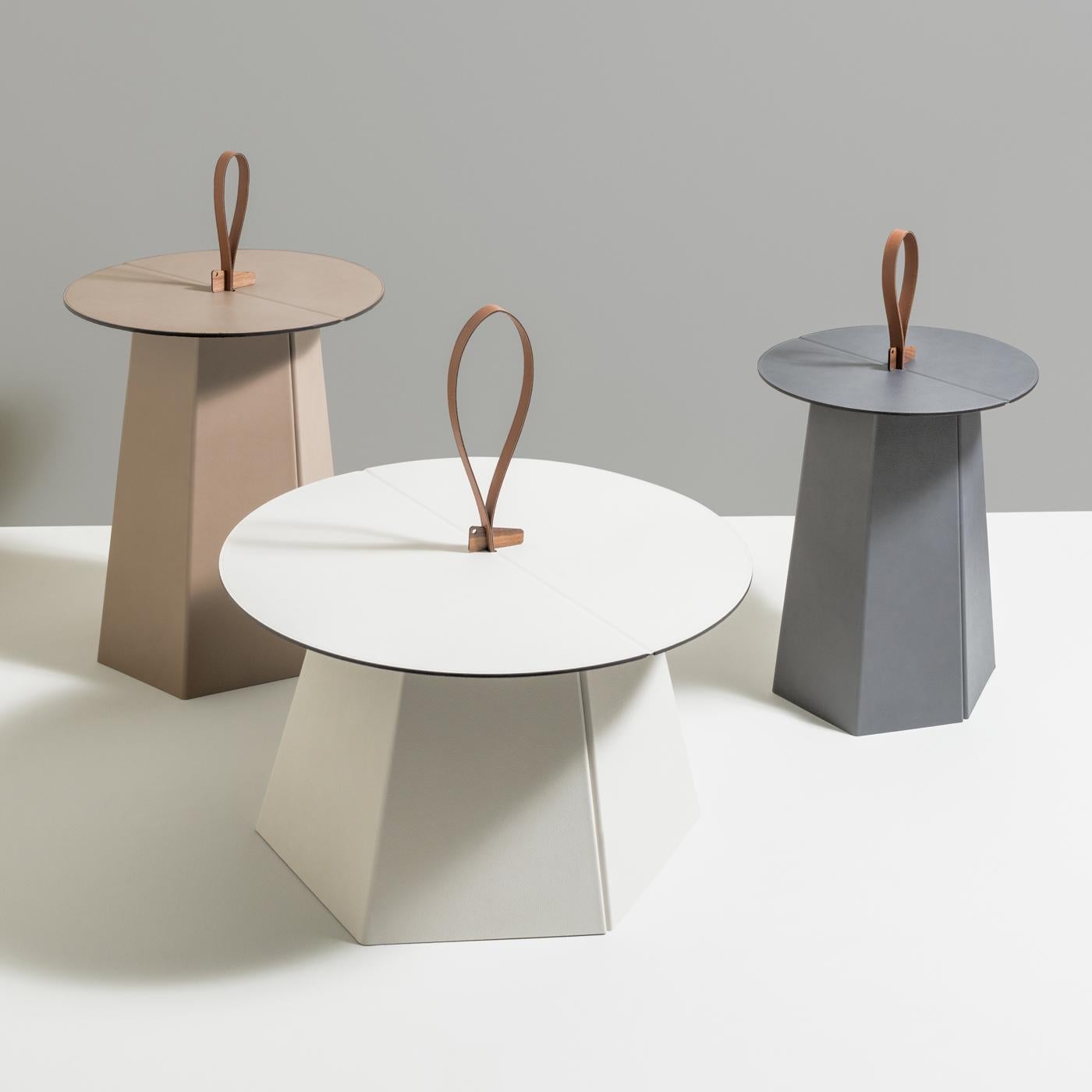 Functionality meets style in this captivating side table defined by sculptural lines, luxurious material, and an easy-to-use foldable design. Entirely handcrafted of grainy leather, this must-have accessory has a hexagonal pillar base and a round