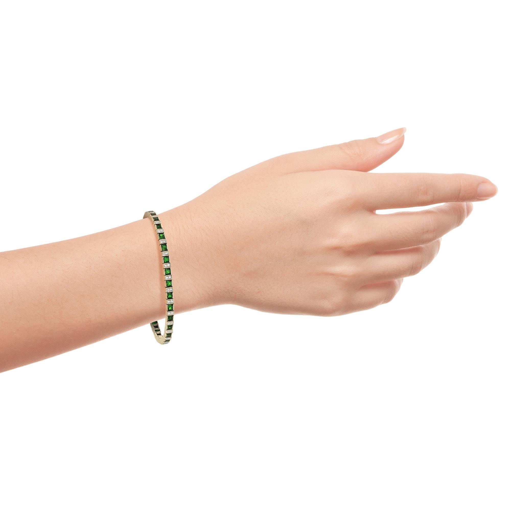 A gorgeous gemstone line bracelet from the Art Deco era! Crafted in 14K yellow gold, this fabulous piece features an alternating pattern comprised of sections of emeralds and diamonds. The bracelet fastens at a push clasp seamlessly hidden within