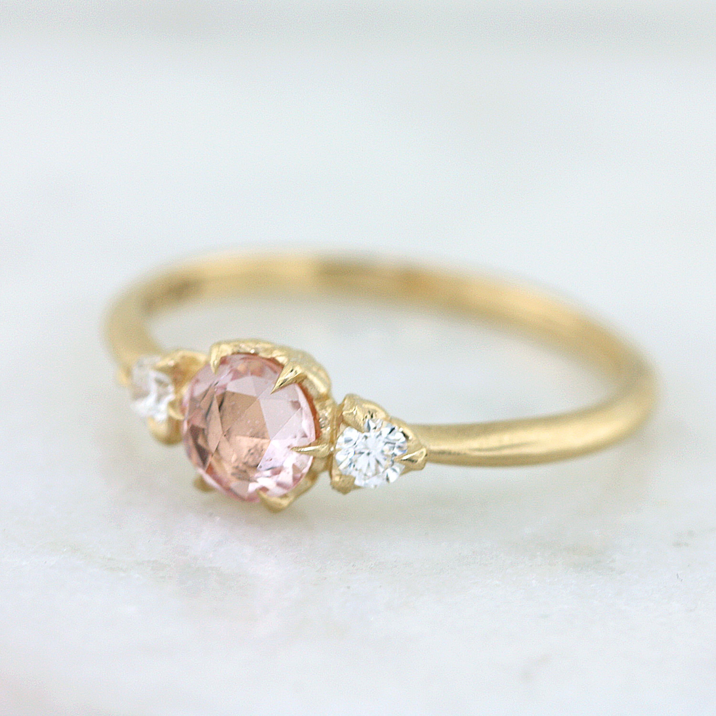 Gold leaves curl up to hold this peach .5ct rose cut sapphire, with accent Canadian diamonds. The glow and sheen on this ring is beautifully understated. Set in 14K 100% recycled gold.

- Finger size 6.25
- Available for customization
- Appraisals