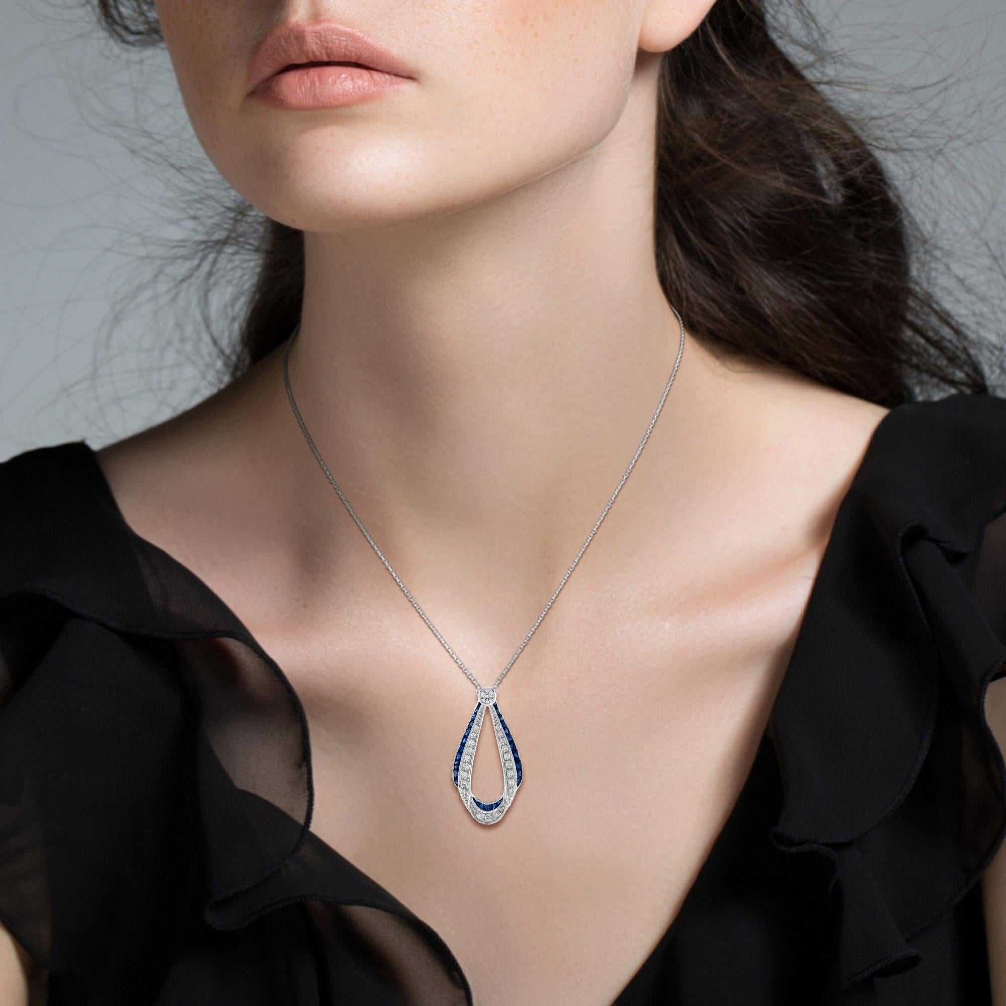 This Art Deco style pendant necklace is absolutely stunning, extraordinary. Over 2 carats of vivid and exceptional blue sapphires border the edge of pendant. And 0.43 carats of fine diamonds. 
Artful and precise work in the 18k white gold combine