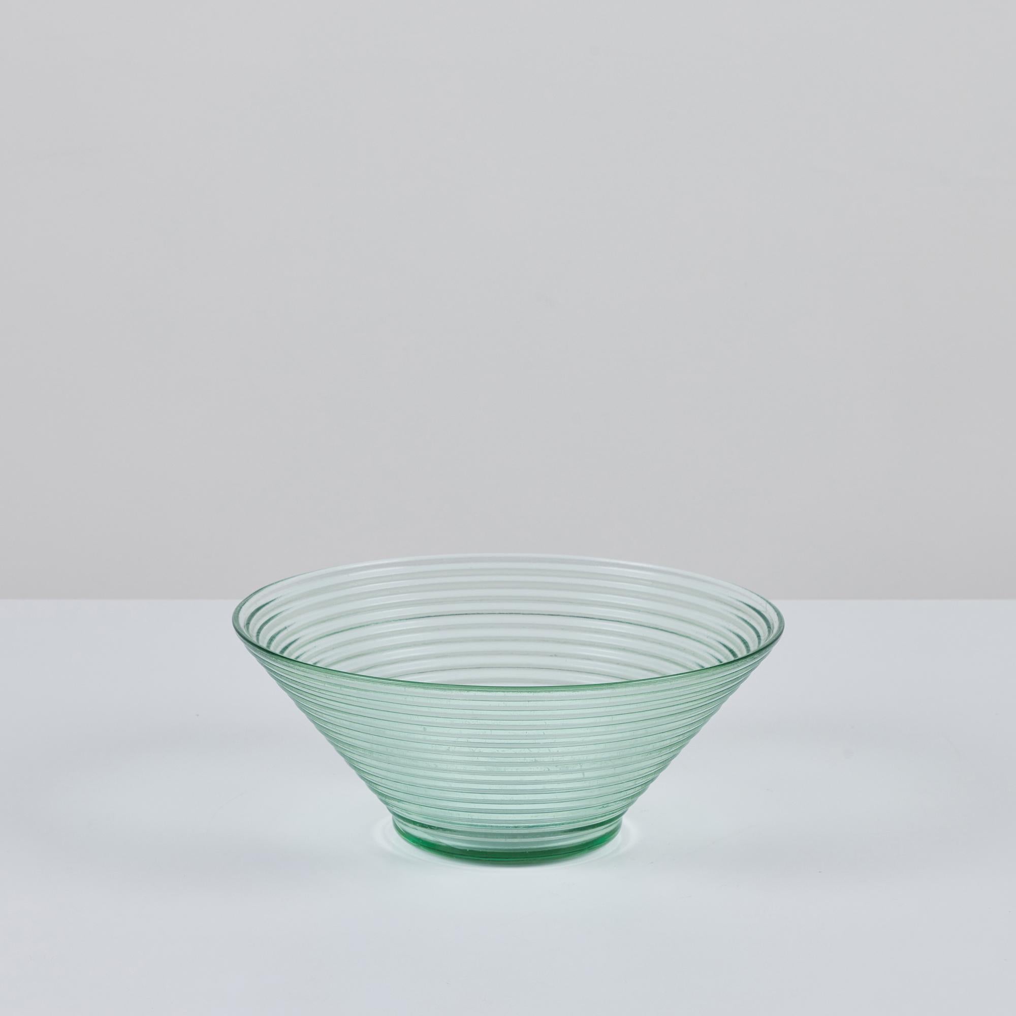 From Aino Aalto’s 1930s collection of glass pieces for Iittala of Finland. This design is made of pressed glass inspired by ripples of water with a slight greenish tint. Originally known as the Bölgeblick design, the bowl was made to easily stack