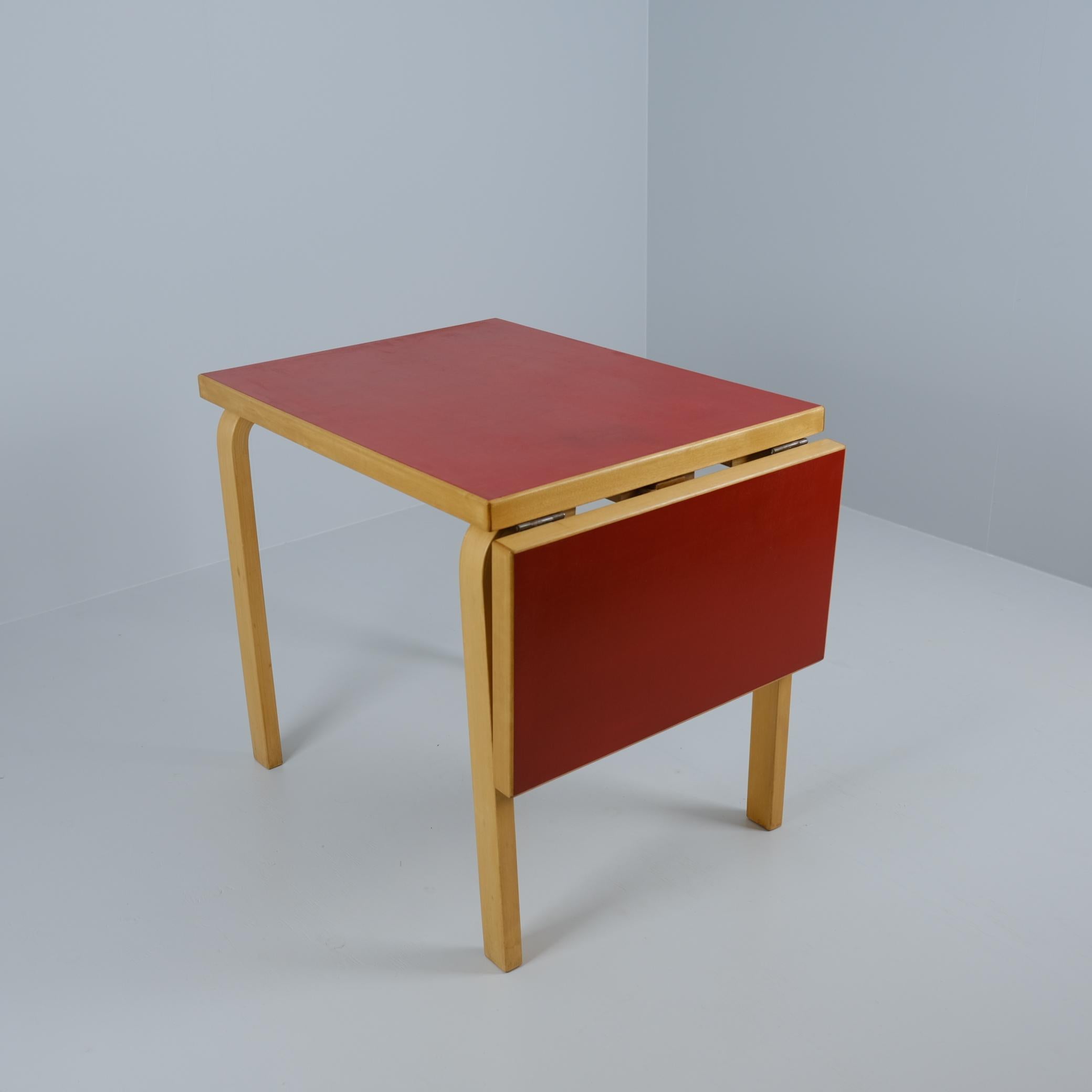 A petit foldable table model DL82 by Artek in birch with a beautiful red linoleum surface, designed by Aino Aalto and manufactured by Huonekalu-Ja Rakennus työtehdas Oy in the 1930s. The materials used by Artek were very duarble and lasted for years