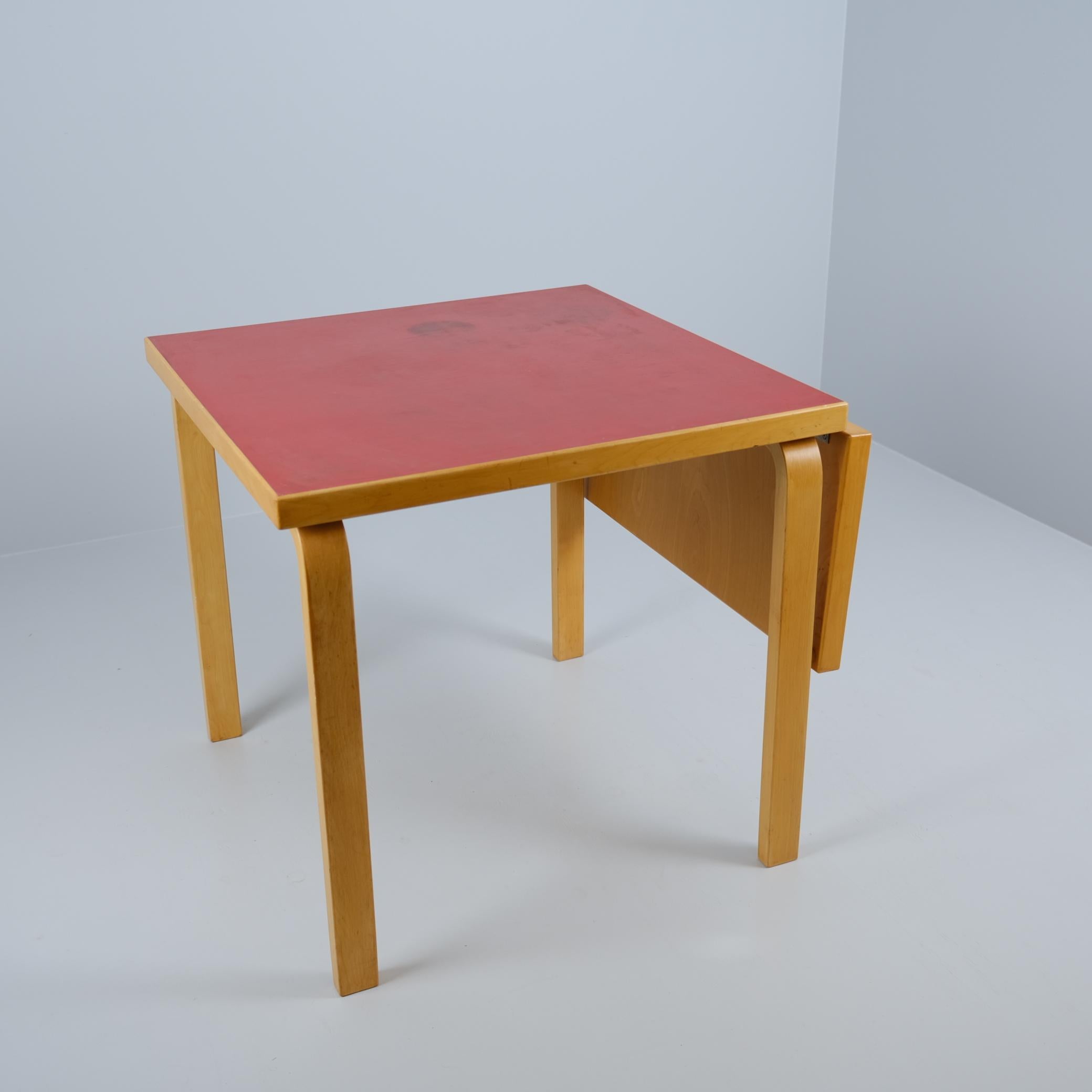 Alvar & Aino Aalto foldable table in birch with beautiful red linoleum surface, designed by Alvar Aalto and manufactured by Artek in the 1950s. The materials used by Artek were very durable and lasted for years and years in good condition regardless