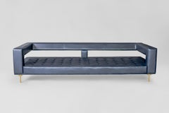 Sofá tapizado en piel azul aire con patas de latón by ATRA