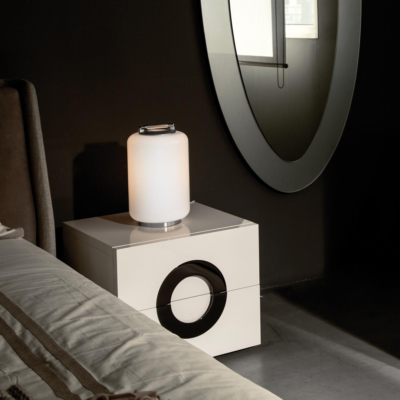 The Air Kan is a modern and stylish collection of table and bedside table lamps that diffuse a soft, ambient light with an exclusive and attractive look. Consisting of a satin nickel frame enriched by a cylindrical diffuser of white hand-blown