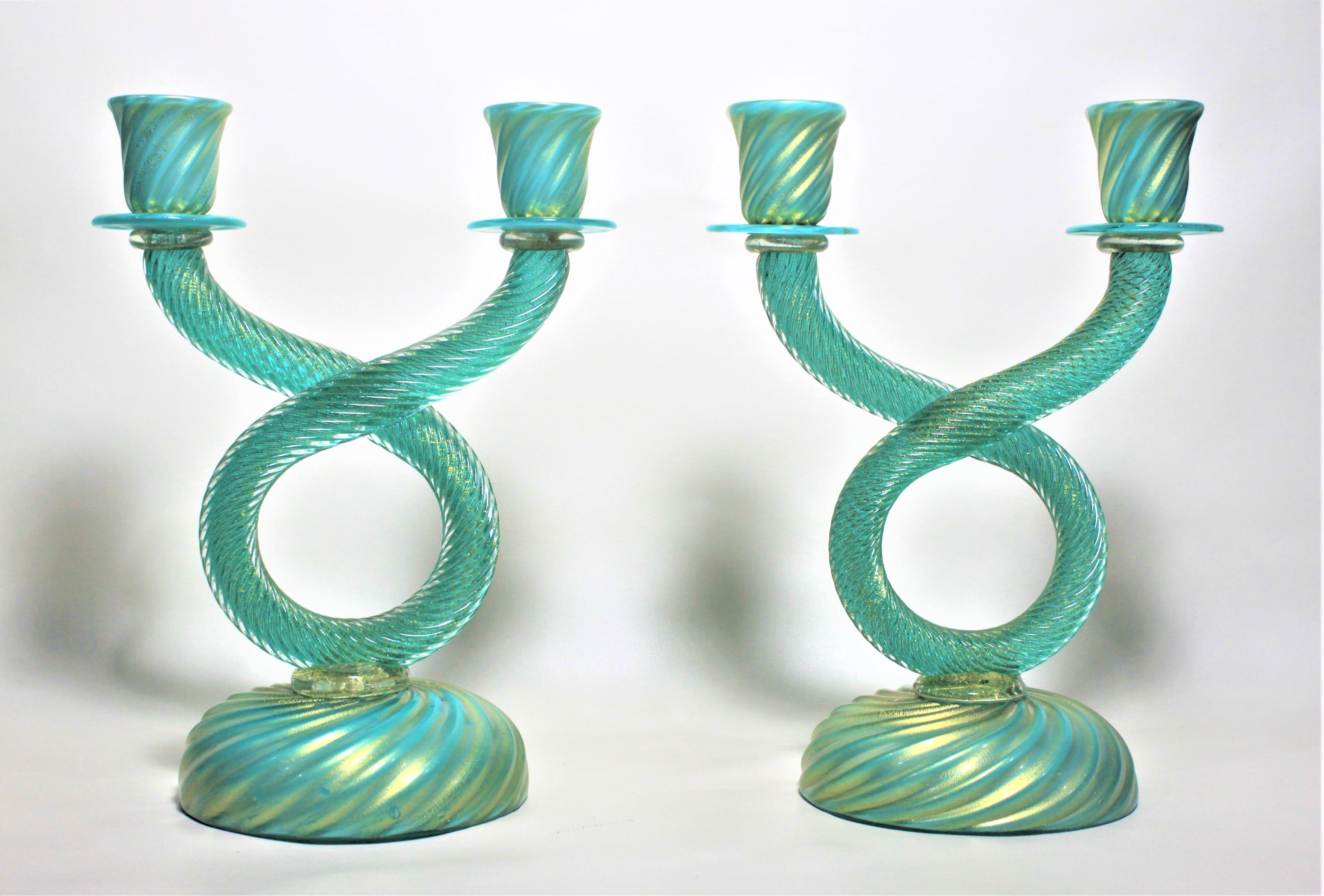 Large pair of midcentury Murano cased blue and green double candlesticks done in the style of Barovier & Toso. These candlesticks executed in a dark emerald green swirled base, swirled rope style risers and topped with swirled and cased green and