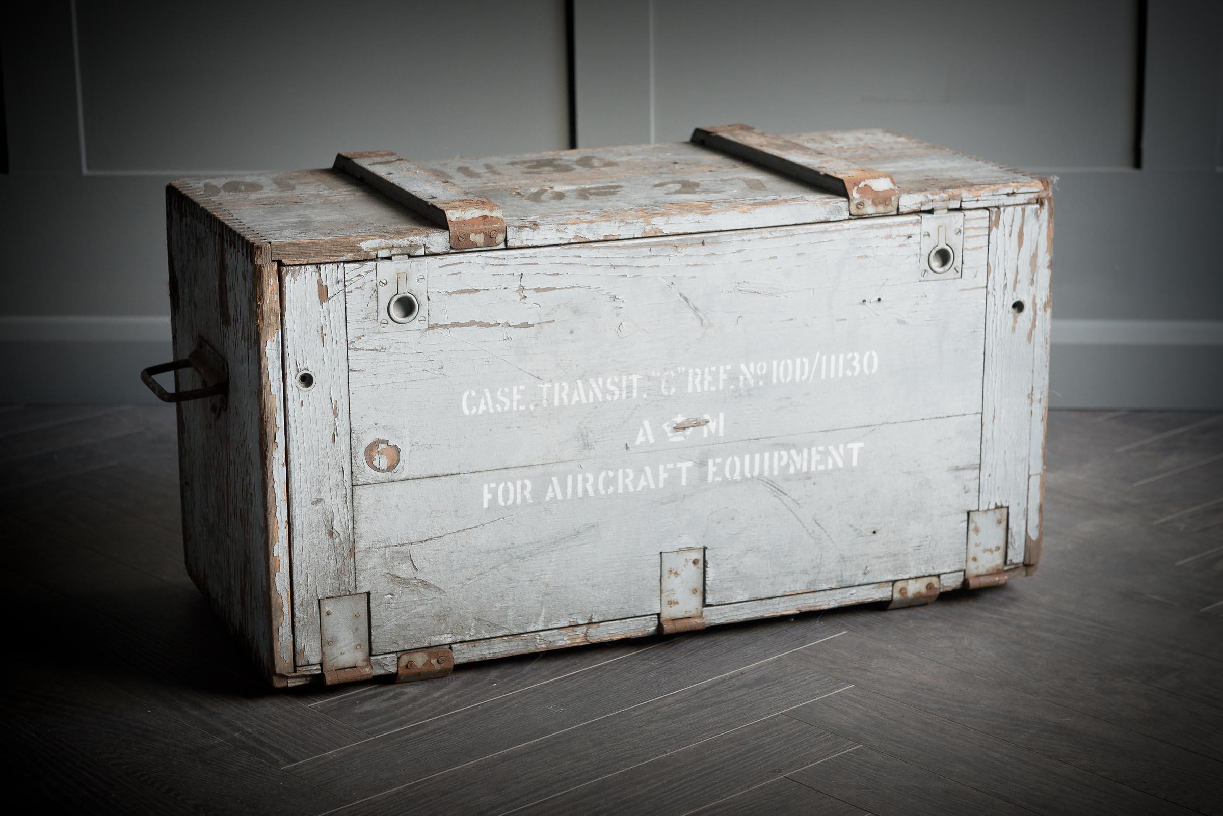 Wooden aircraft parts box with two simple metal handles either side of the box. Stamped on the side in white is military information. The box is consistent with age and use.