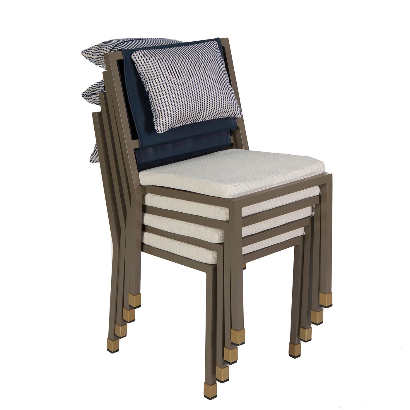 This set of four stackable chairs boasts an elegant and modern design. Handmade with high-quality materials suitable for the outdoors, each chair features a varnished aluminum structure, with legs partly covered in hand-stitched leather and