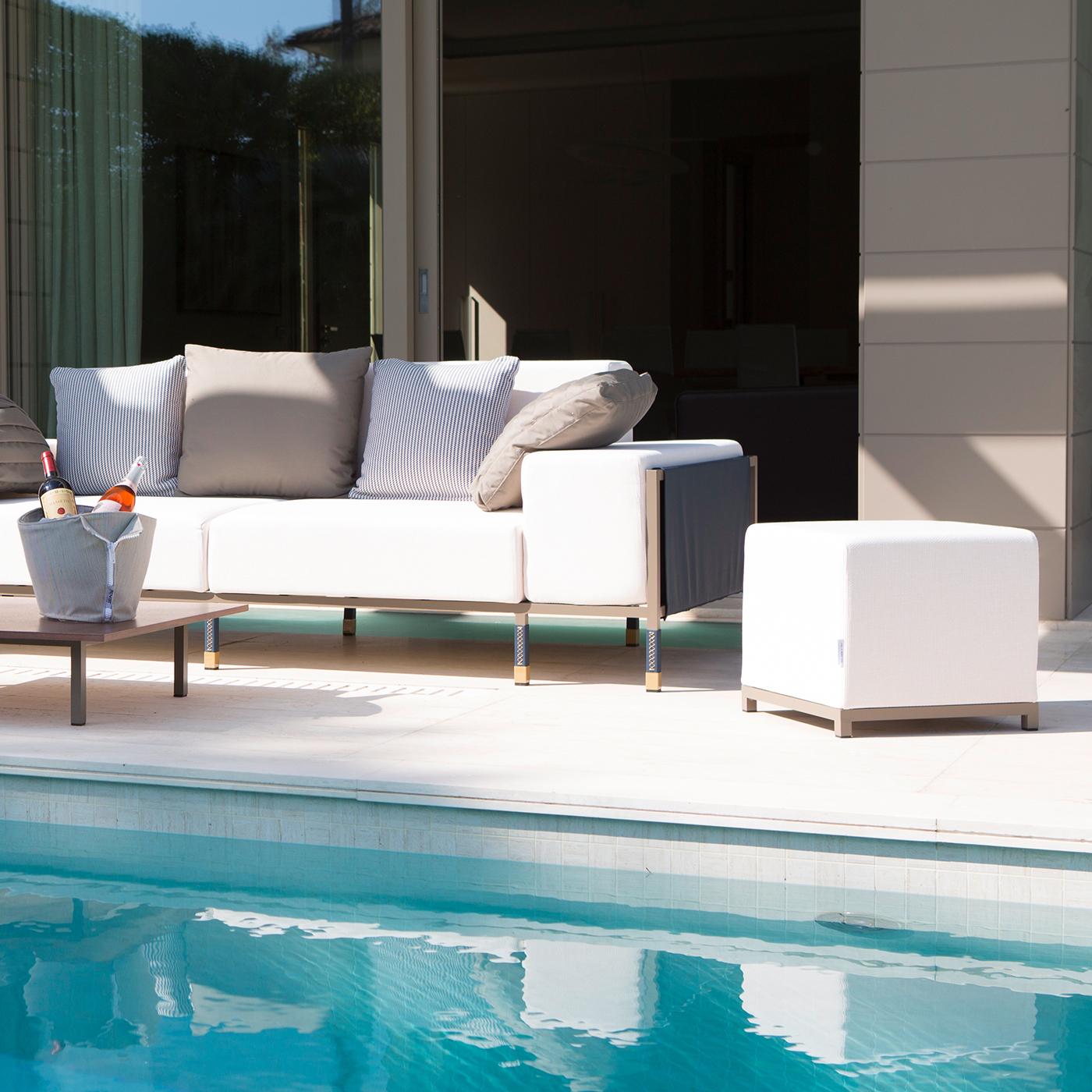Boasting an elegant and modern allure, this sofa is a sophisticated piece of outdoor furniture. It comprises a lightweight varnished aluminum structure, with legs partly covered with hand-stitched leather and lacquered satin gold feet. The two seats
